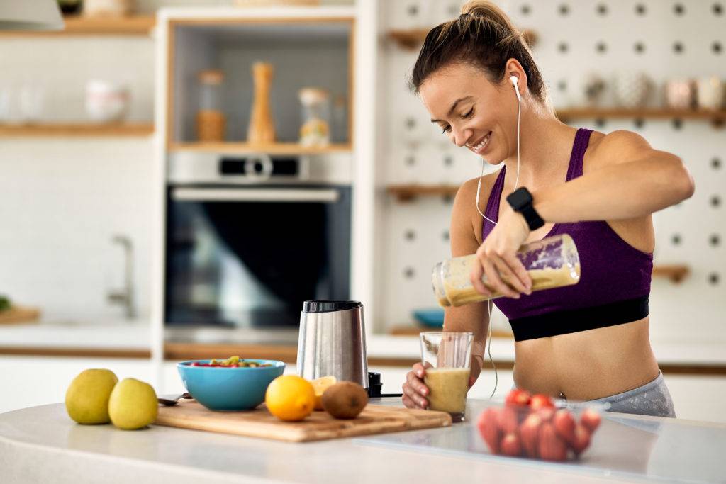 woman over 40 preparing a breakfast smoothie.
